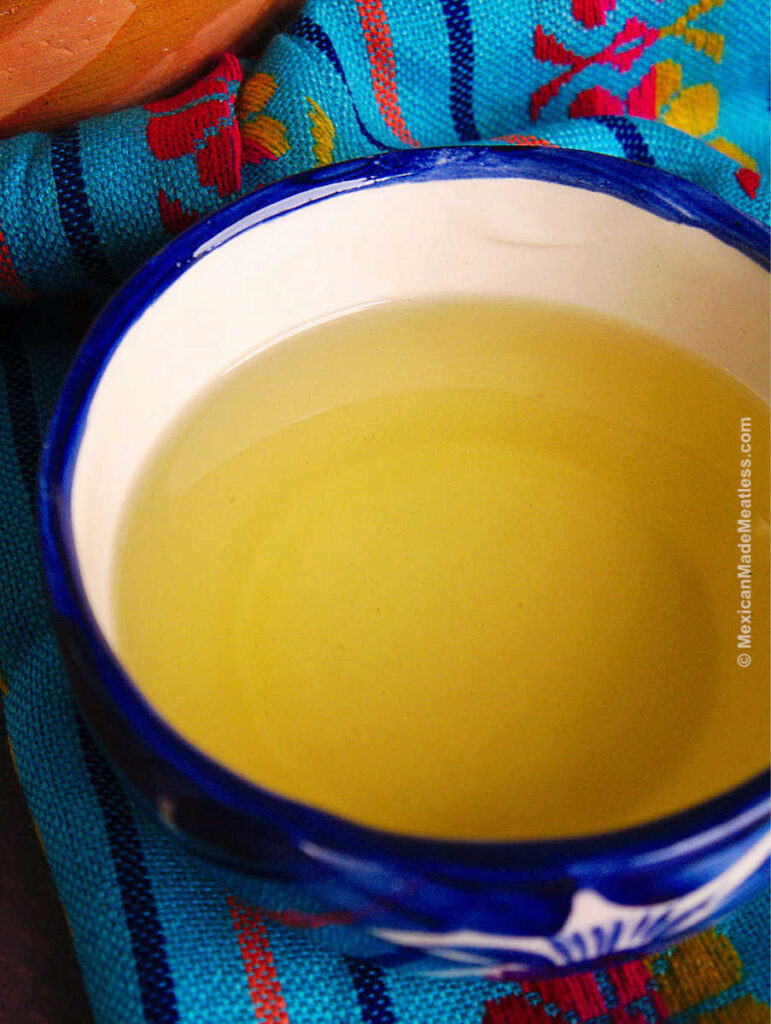 A small white and blue bowl filled with canola oil for making tamales.