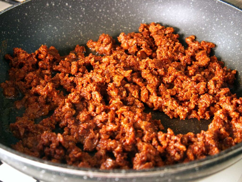 View inside a frying pan filled with vegan chorizo sausage that's been sauteed.