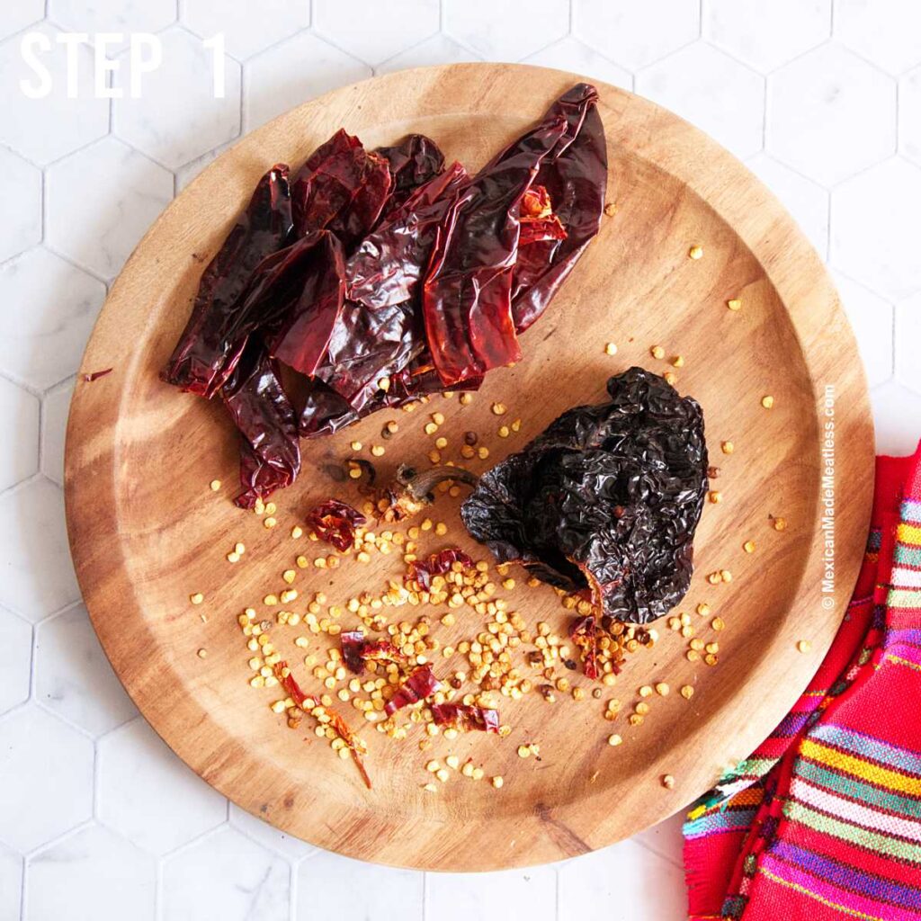 A wood plate with Mexican dried red chiles that have been deseeded.