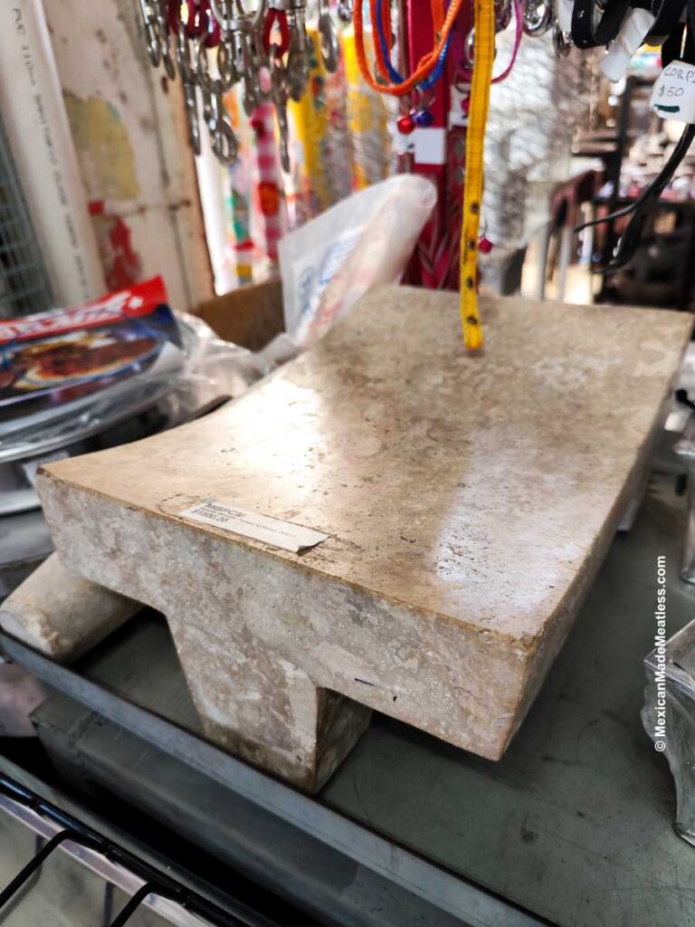 A polished stone metate on display at a small Mexican mercado store.