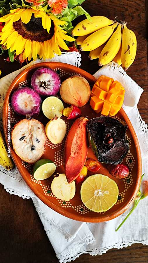 View from above of a wood table filled with exotic Mexican tropical fruits sliced open.